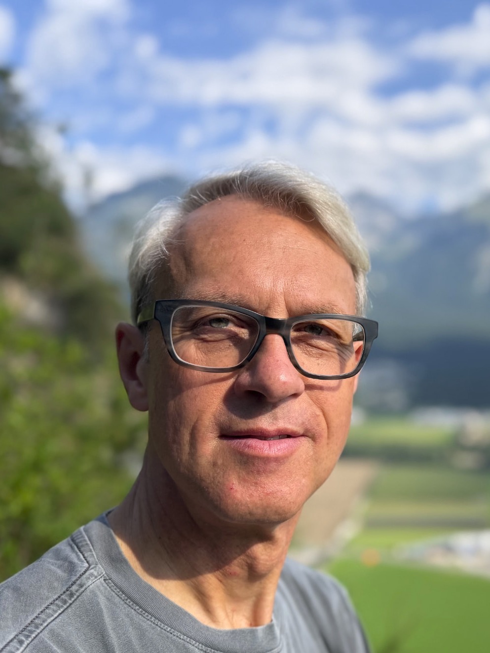 Dr. Uwe Heil, Porträt vor Tiroler Bergpanorama